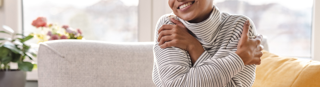 smiling woman hugging herself