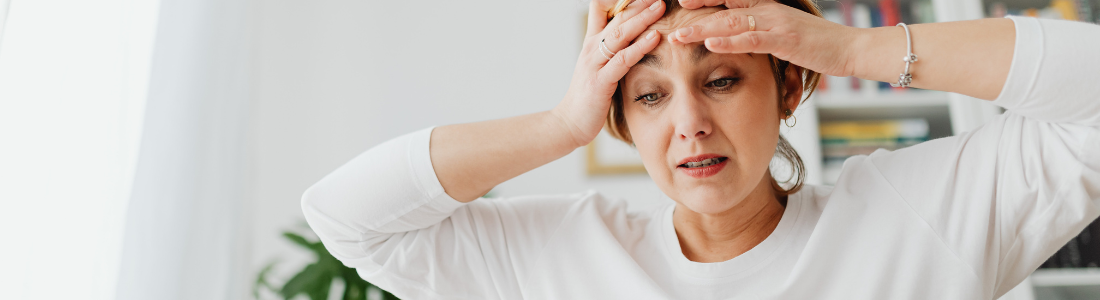 woman grabbing her head looking overwhelmed