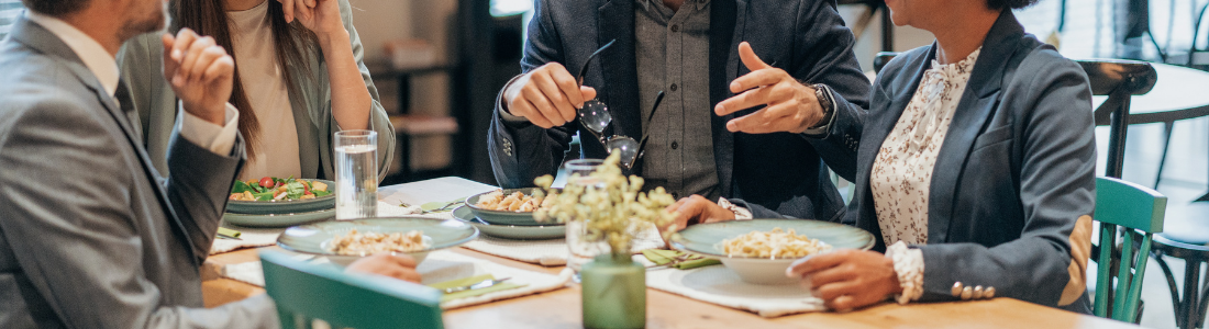 group of smartly dressed people sitting at table having lunch